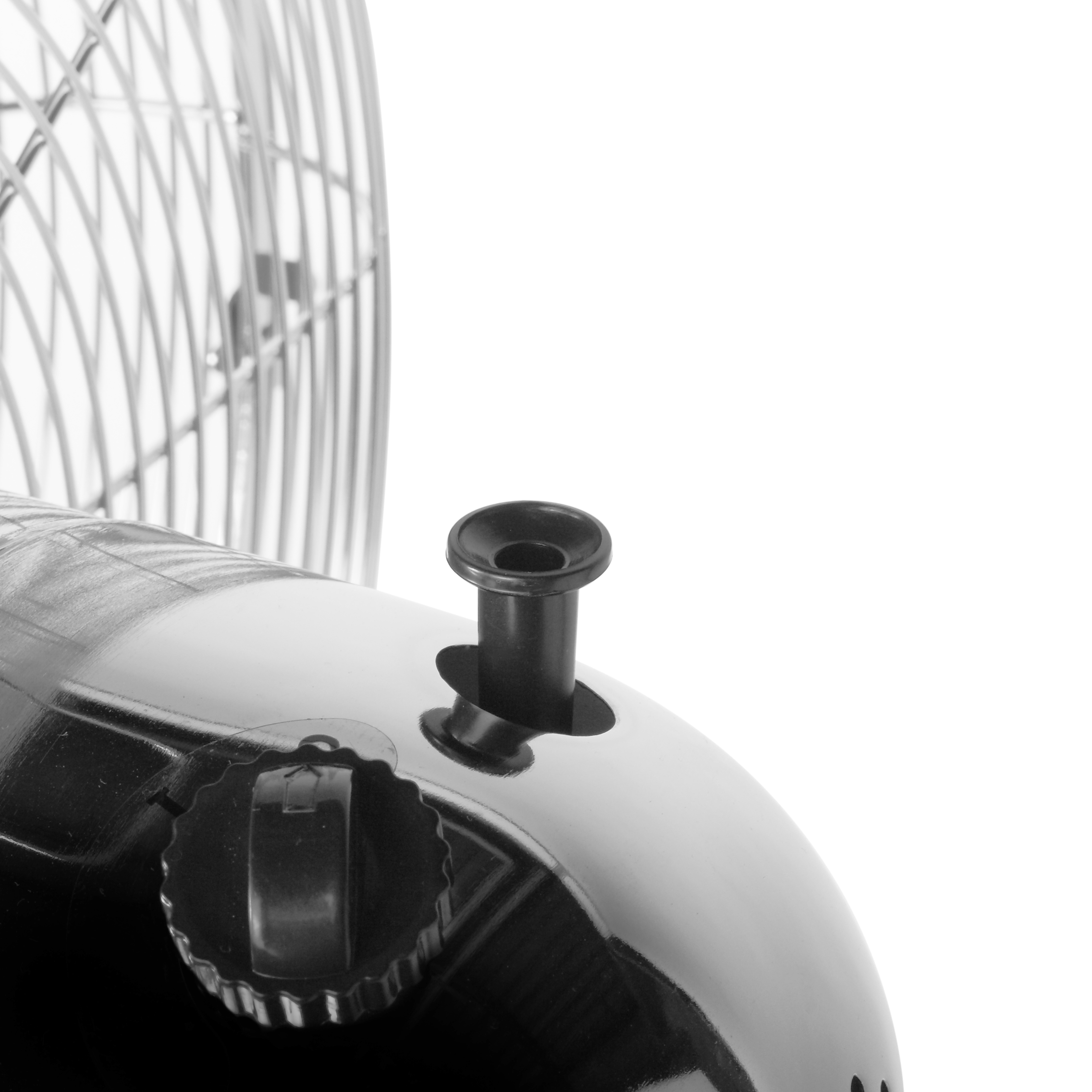 Primer plano de un ventilador, con un botón y mando de control negros.