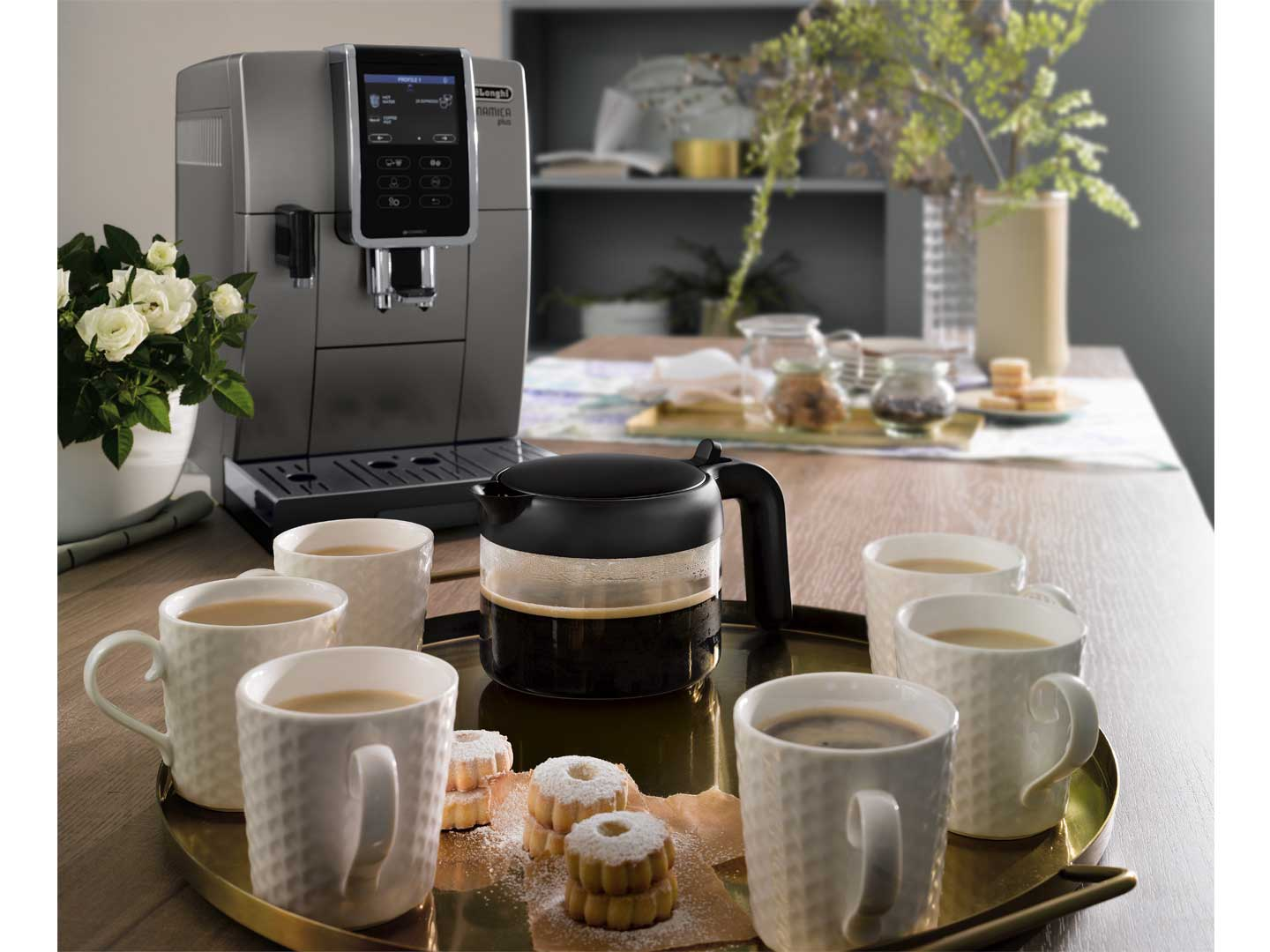 Machine à café avec tasses de café et biscuits sur une table en bois.