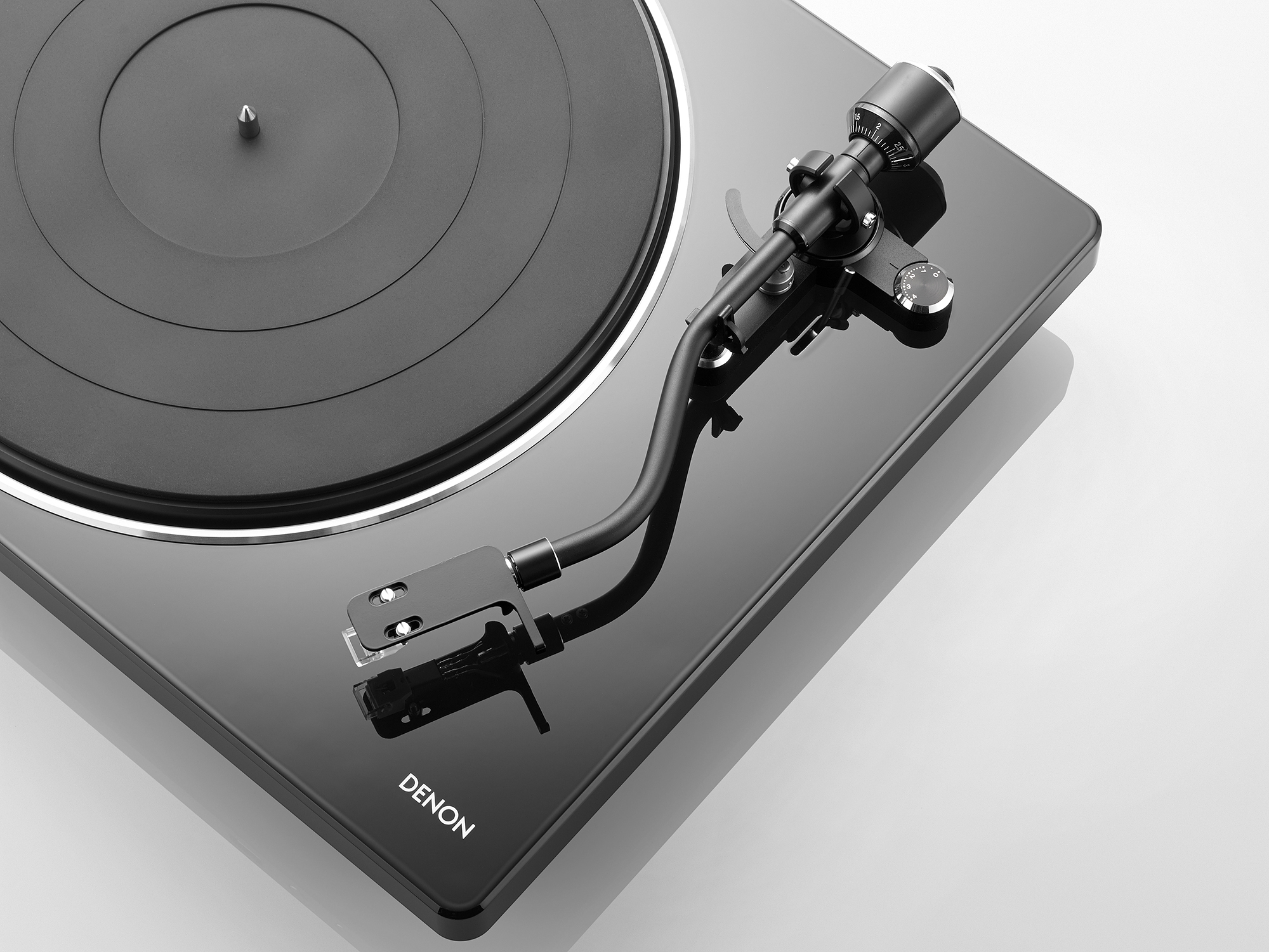 Schwarzer Denon Plattenspieler. Er hat einen schwarzen Plattenteller und Tonarm. Die Basis ist glänzend.