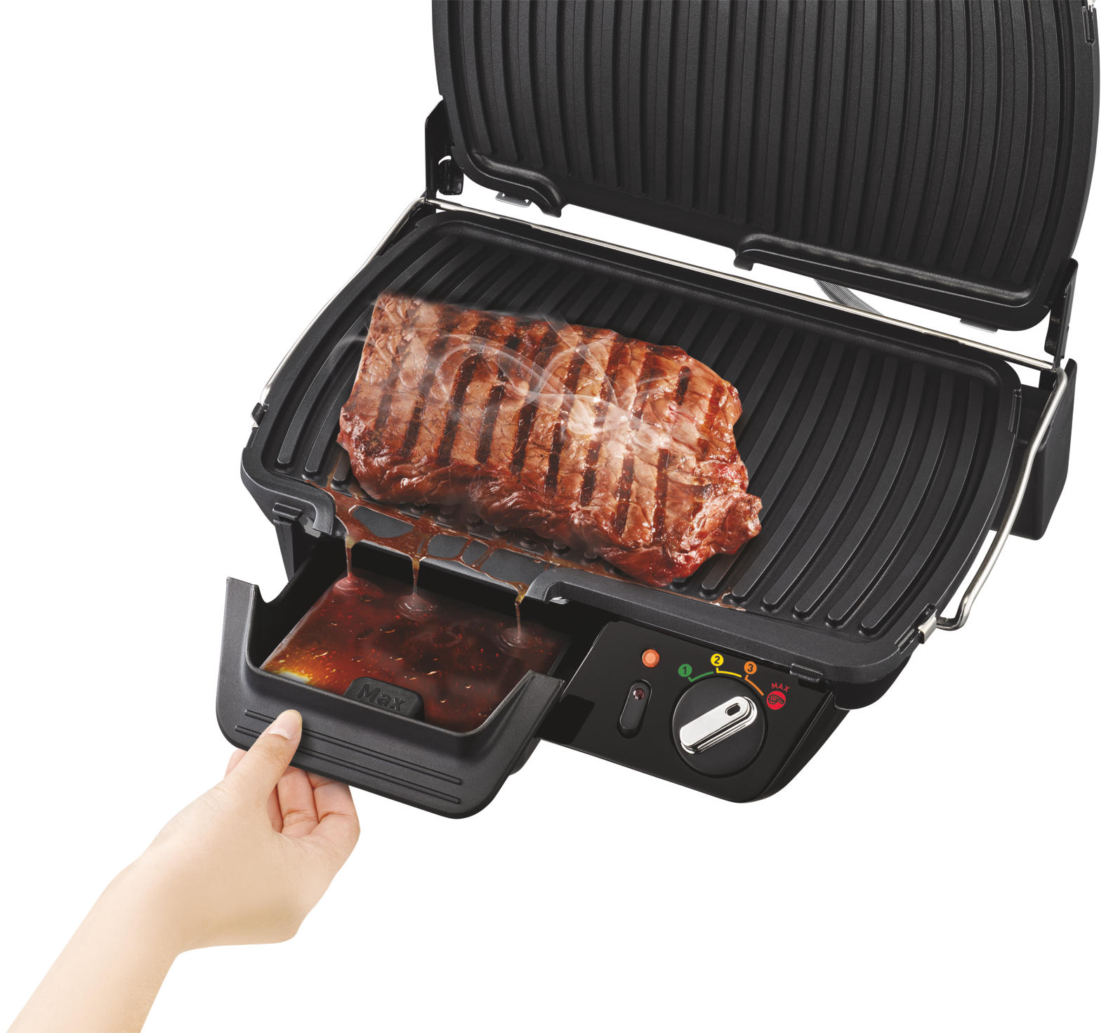 Grill with steak on, sauce dripping into a tray, hand reaching for the tray.