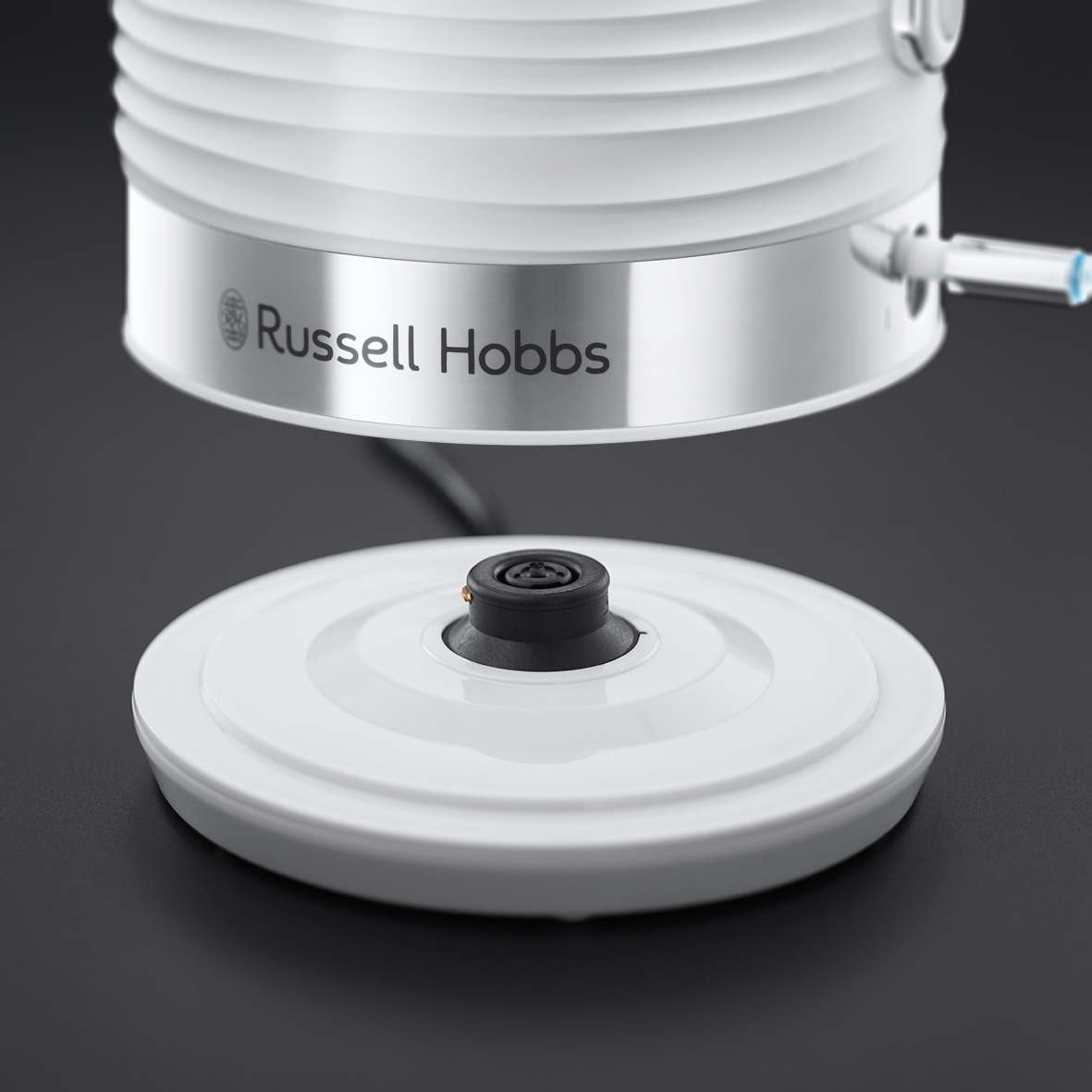 Fehér Russell Hobbs elektromos vízforraló fekete felületen, közelkép.