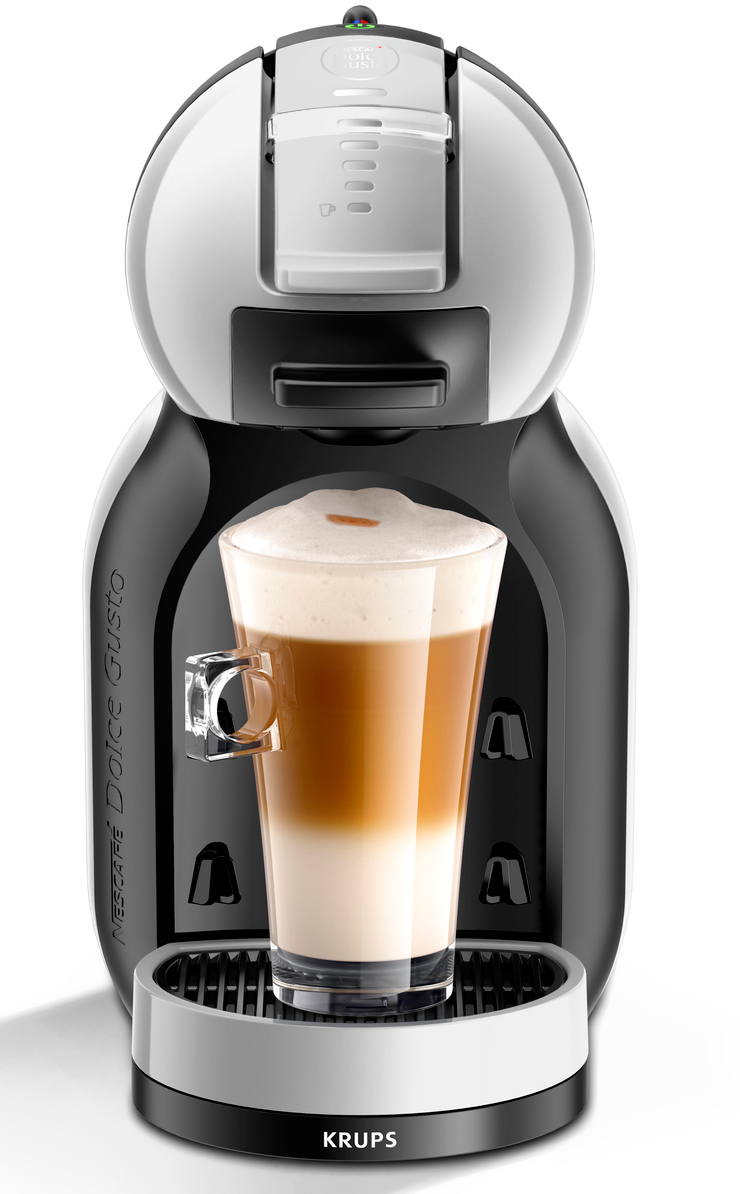 Machine à café avec un verre de latte en couches devant.