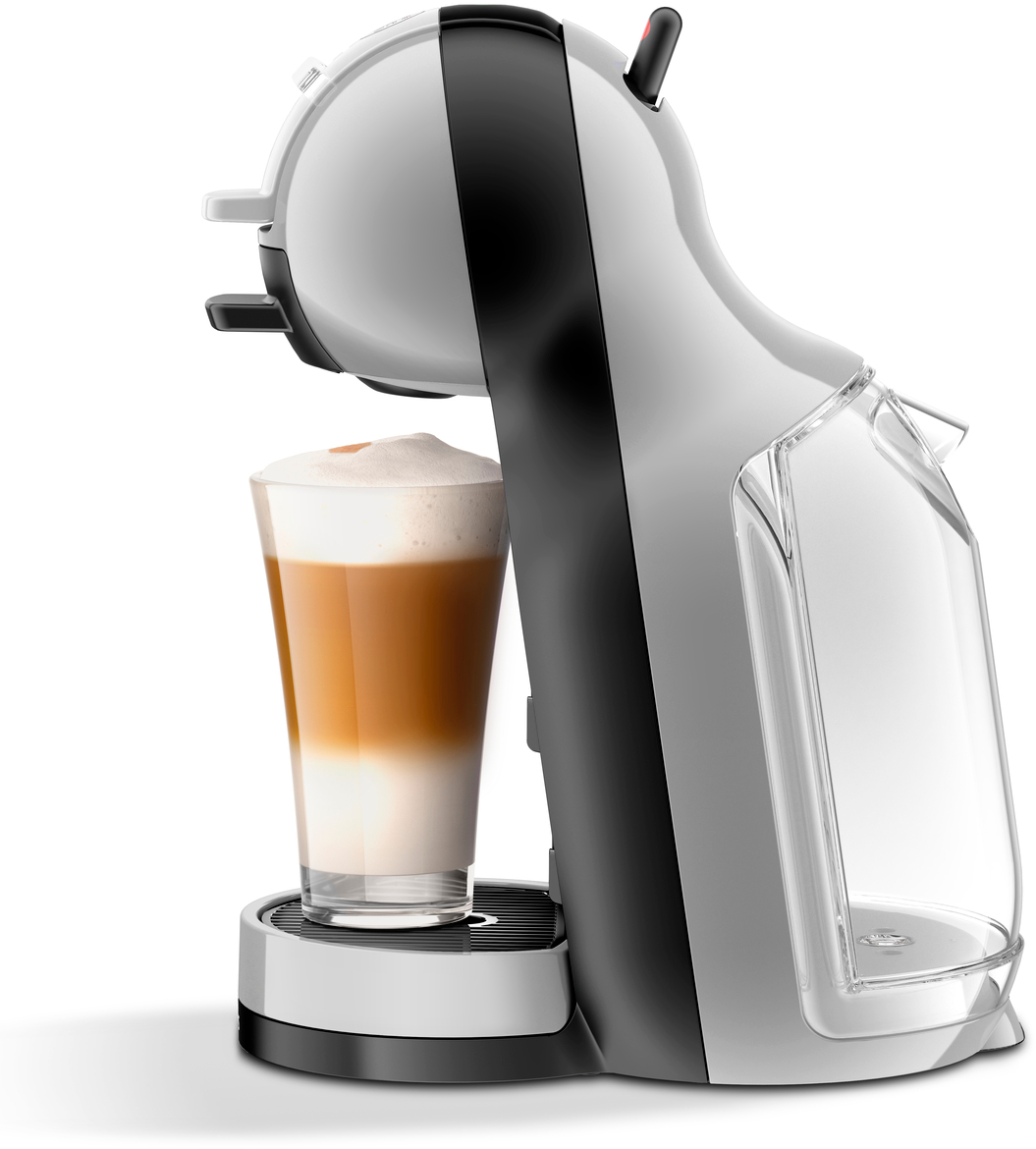 Une machine à café blanche et noire avec un verre de latte, de la mousse blanche sur le dessus.