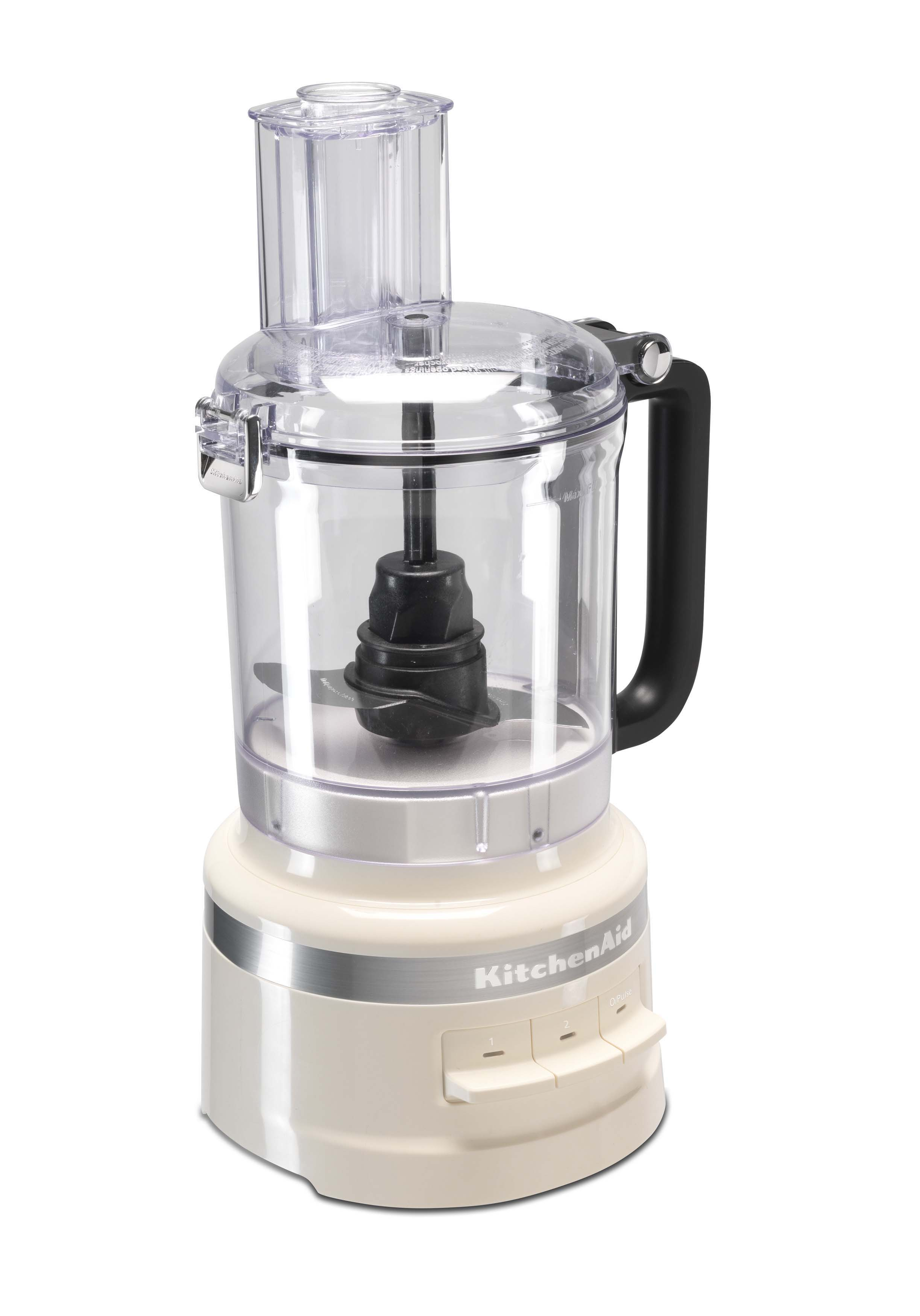 Cremefarbene KitchenAid Küchenmaschine. Sie steht auf weißem Hintergrund. Sie hat einen Griff, eine Klinge und Knöpfe an der Basis.