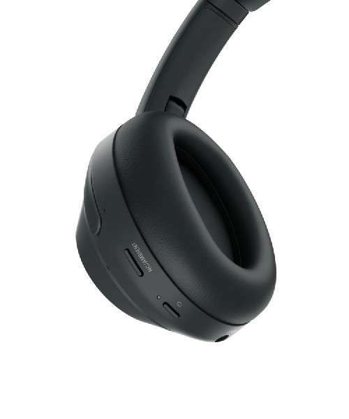 Un auricular negro sobre la oreja, mostrando la copa y los botones.