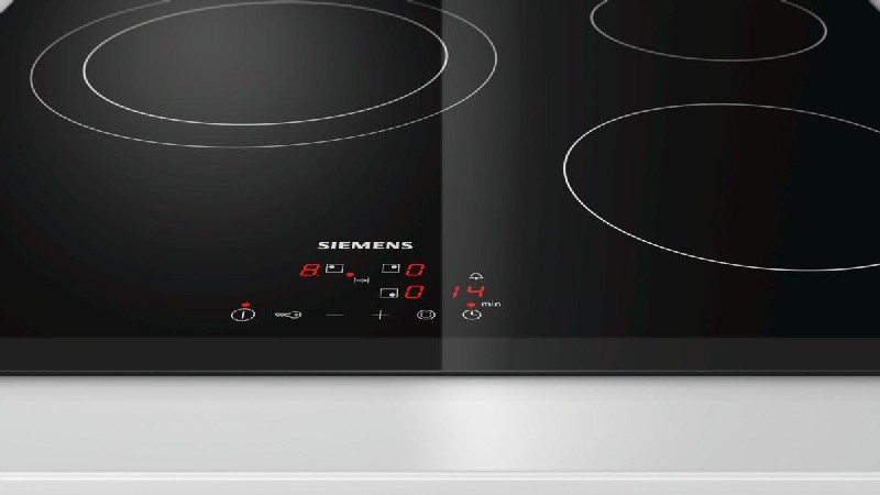 Placa de inducción Siemens negra, con pantalla digital que muestra números.
