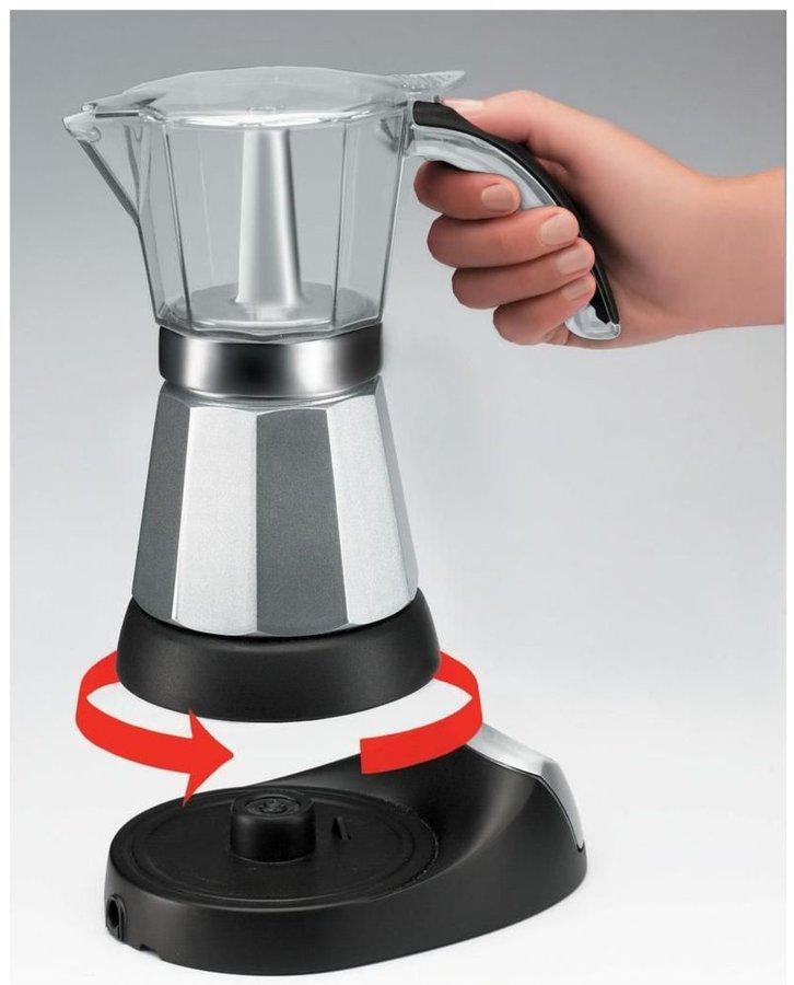 Persona sosteniendo cafetera espresso plateada y negra. Flechas rojas muestran girando la base.