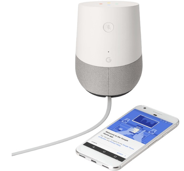 Altavoz Google Home blanco con base gris. Un smartphone muestra la aplicación Google Home.