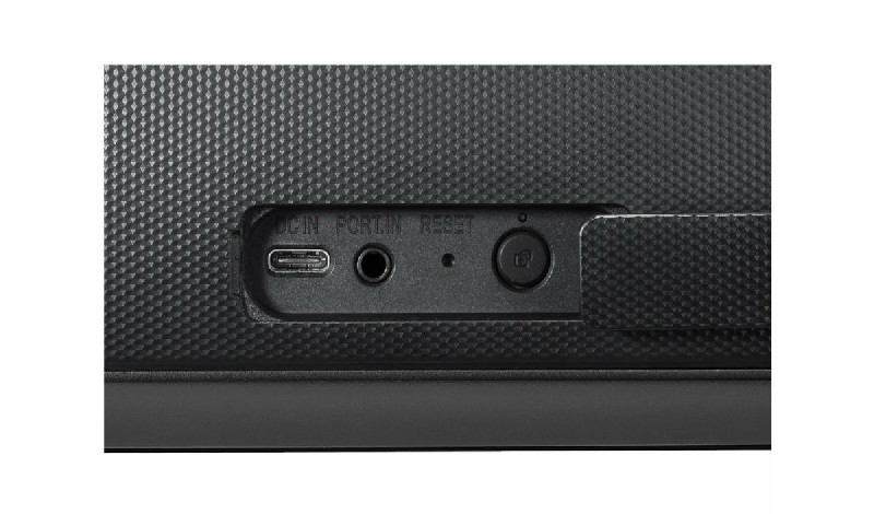 Panel trasero de un dispositivo negro con puertos: USB-C, audio, reinicio. Superficie texturizada. Fondo blanco.