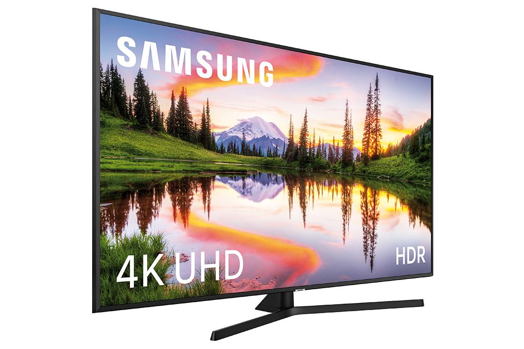 Un televisor Samsung 4K UHD HDR muestra una vista panorámica de un lago y montañas.