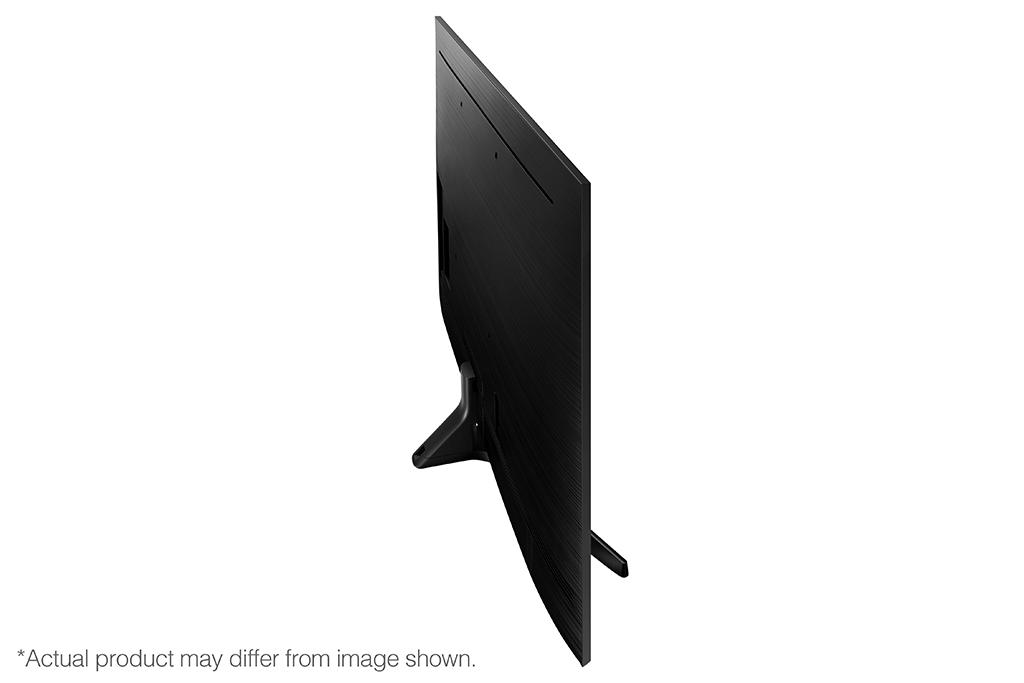 Pantalla de TV negra, vista lateral. El televisor tiene un soporte. El fondo es blanco.