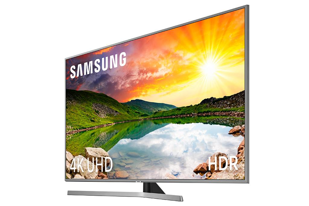 Televisor Samsung mostrando una puesta de sol vívida sobre un lago y montañas. La marca es visible.