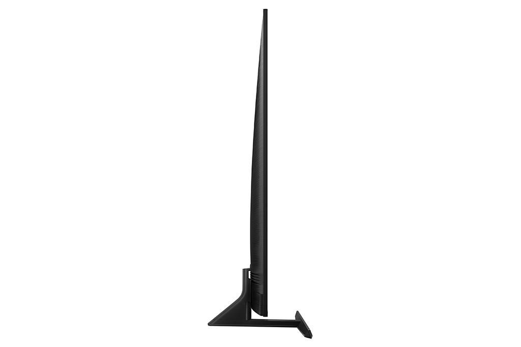 Vista lateral de un televisor negro elegante con un perfil delgado y soporte. El televisor está en una superficie blanca.