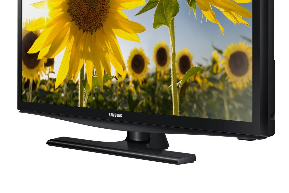 Un televisor Samsung negro con un campo de girasoles en el fondo, con los girasoles enfocados.