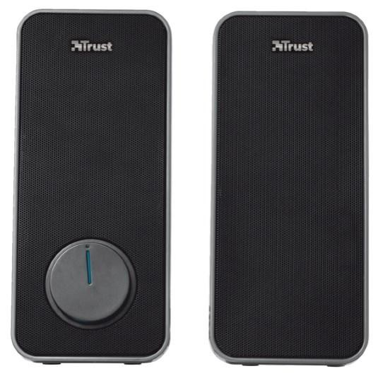 Dos altavoces Trust negros. Cada uno tiene una rejilla frontal y un dial de volumen.