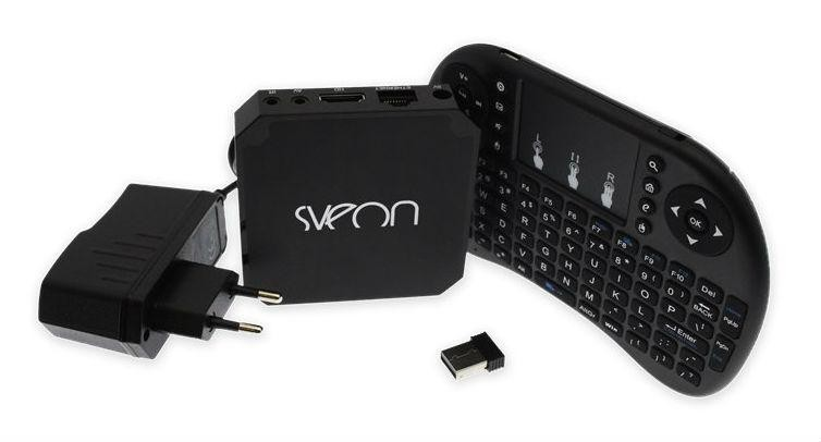 Un dispositivo multimedia negro, un adaptador de corriente y un teclado sobre una superficie blanca. La marca es SVRON.