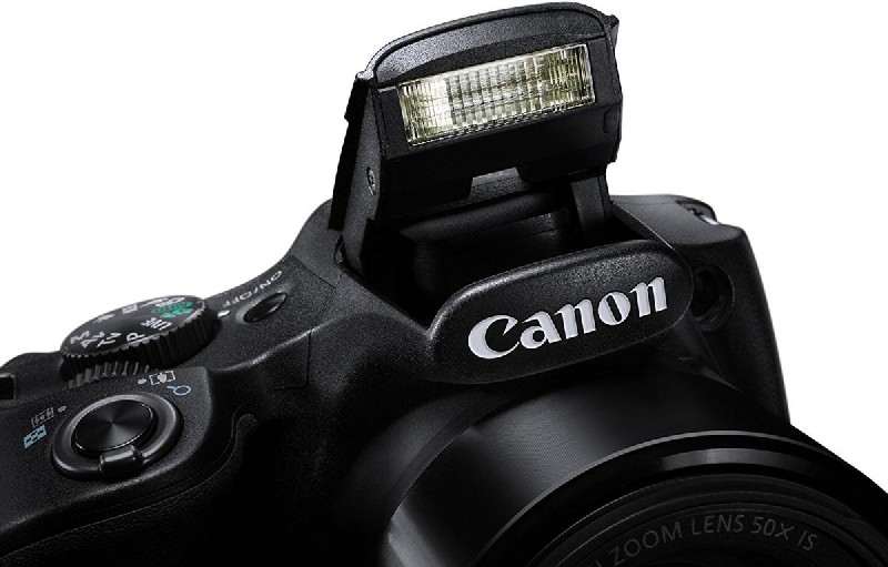 Primer plano de una cámara Canon negra con el flash desplegado y el logo Canon.