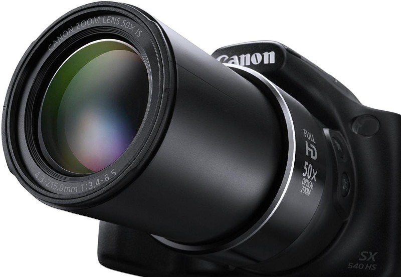 Primer plano de la lente de una cámara Canon, mostrando el zoom y otras especificaciones en la lente.