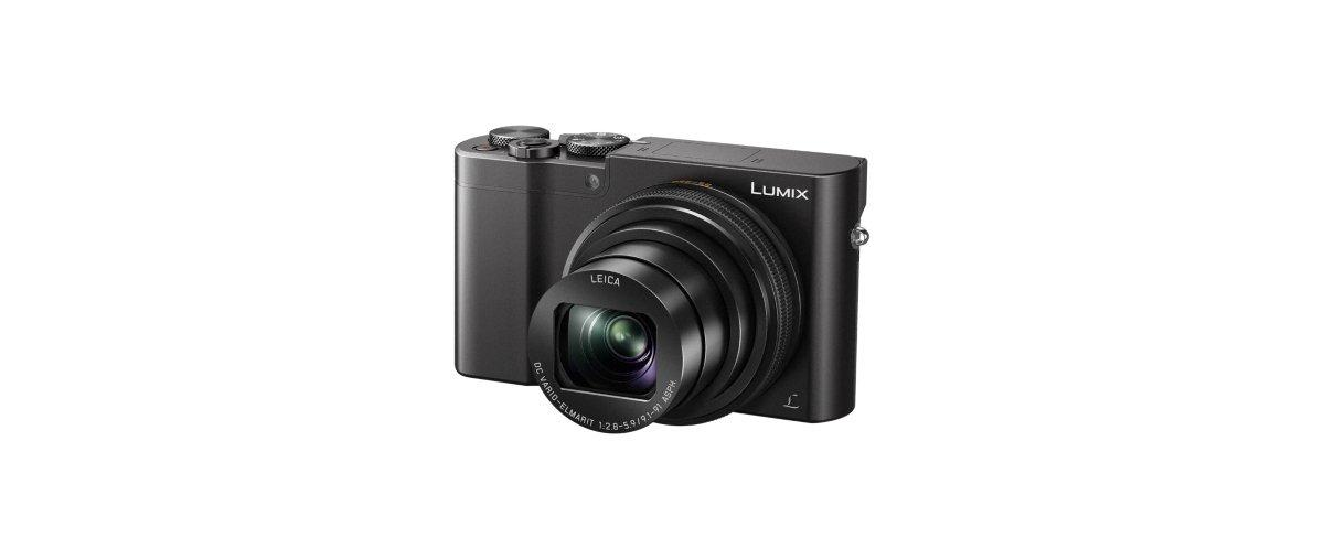 Una cámara Lumix negra con lente y botones, sobre un fondo blanco. La cámara es negra.