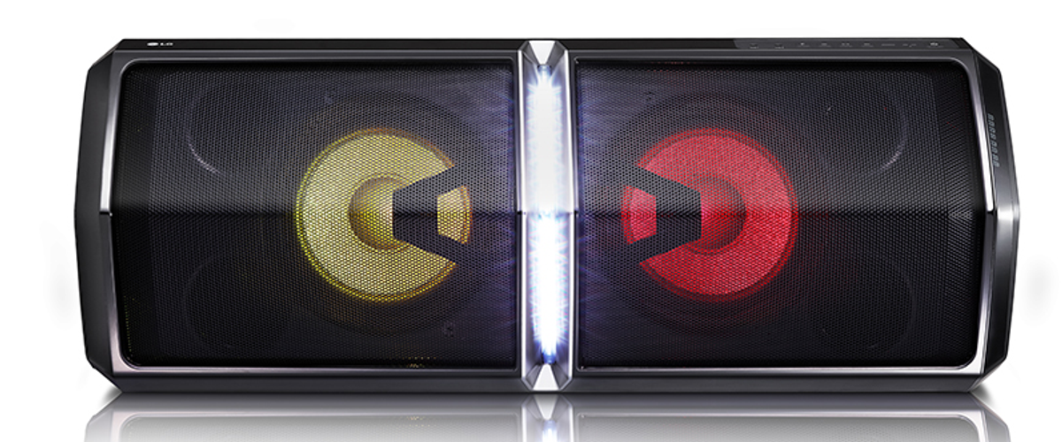 Altavoz negro y plateado con barra de luz y dos conos de altavoz con luces de color.
