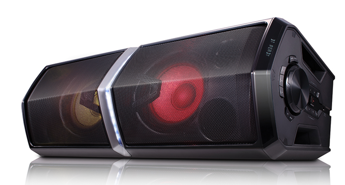 Altavoz LG negro con frontal de malla y luces rojas y amarillas. Panel de control en el lado derecho.