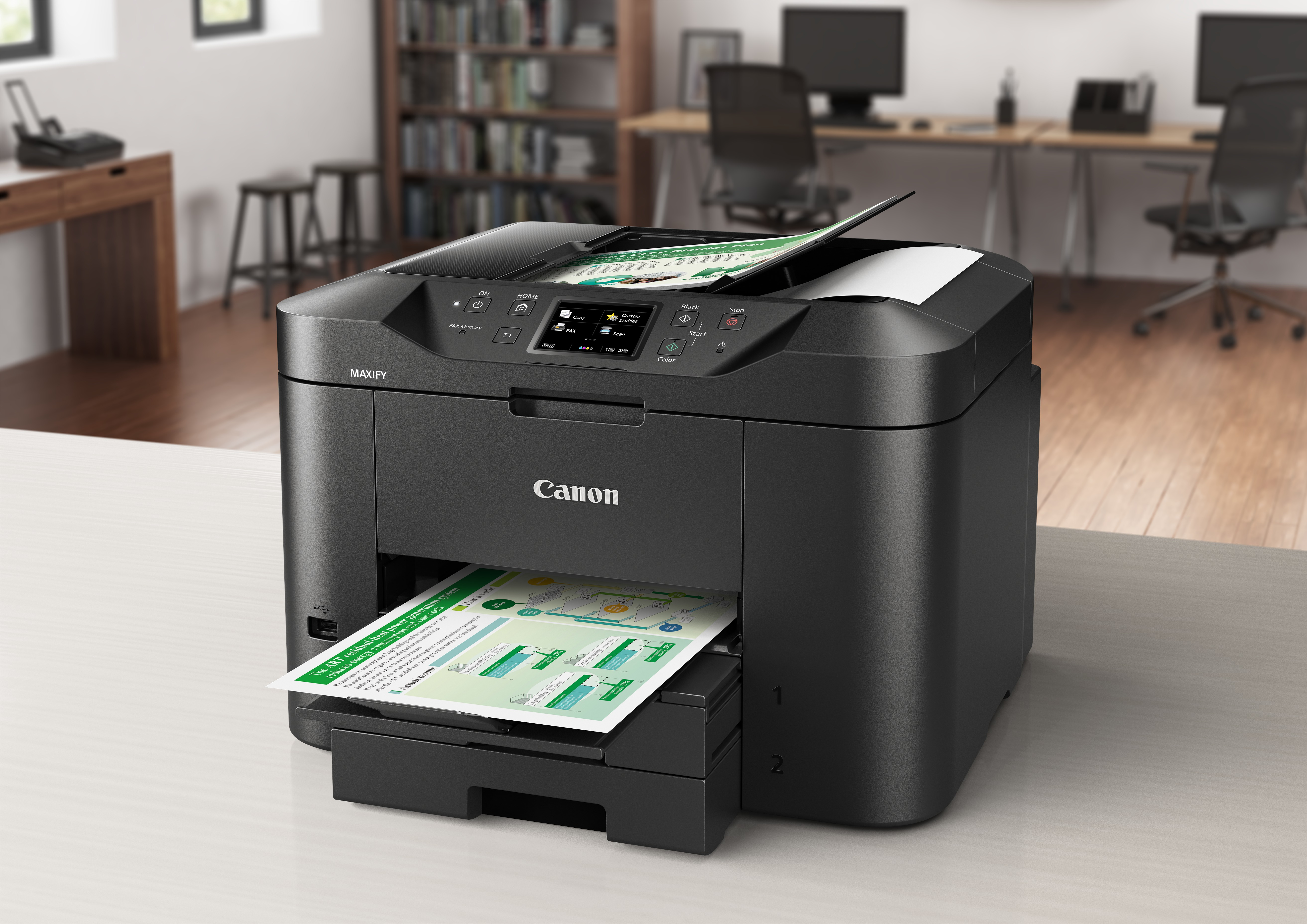 Impresora Canon negra imprimiendo papeles con diagramas verdes y blancos sobre una mesa blanca.