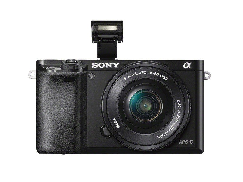 Cámara Sony negra con lente y flash. Fondo blanco. Texto Sony y APS-C.