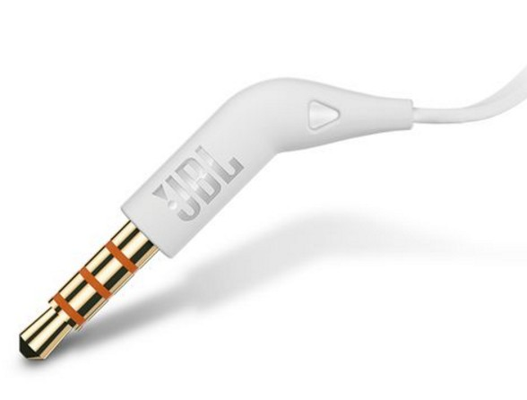 Conector de auriculares blanco con logotipo JBL. Conector dorado y negro. Primer plano.