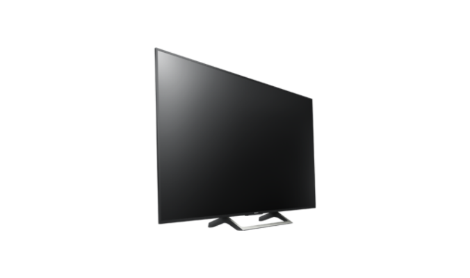 Una pantalla de TV negra sobre un soporte, ligeramente inclinada. Fondo blanco. Diseño moderno.