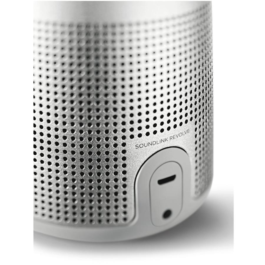 Altavoz cilíndrico plateado con pequeños agujeros y el texto 'SOUNDLINK REVOLVE'.