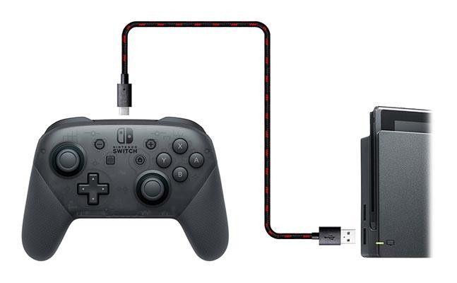 Mando Nintendo Switch conectado a la consola. Mando negro, cable rojo y negro.