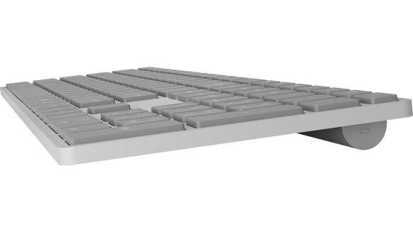 Teclado blanco con teclas grises, visto desde un ángulo bajo.