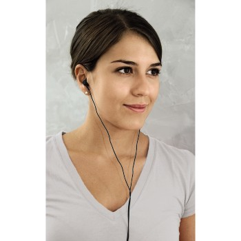 Joven con camiseta gris claro, con auriculares, mirando a la cámara.