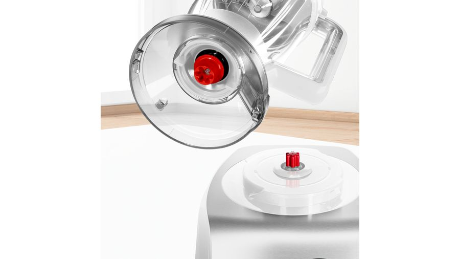 Gros plan d'un mixeur. Montre la zone de fixation et un bouton rouge.