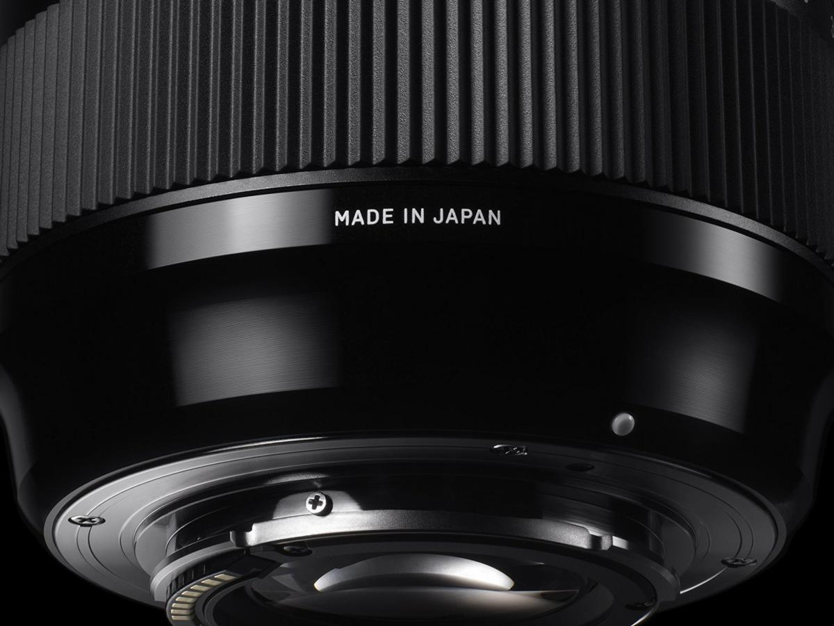 Primer plano de una lente negra con texto 'MADE IN JAPAN' en el lateral.