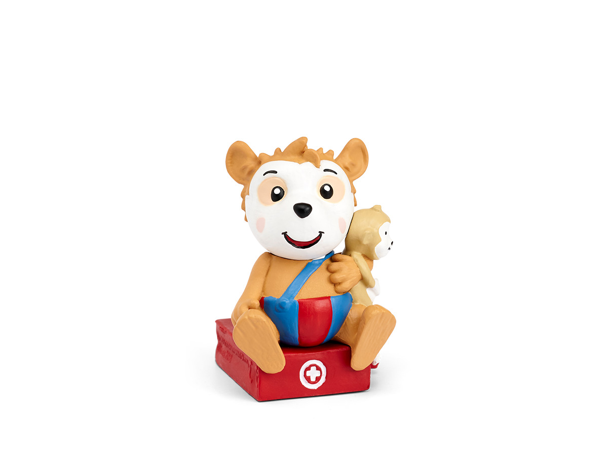 Cartoonbär mit Spielzeug, sitzt auf roter Erste-Hilfe-Box.