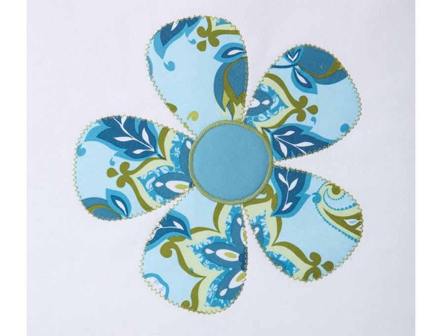 Un diseño de flor azul y verde hecho de tela sobre un fondo blanco, con un contorno cosido.