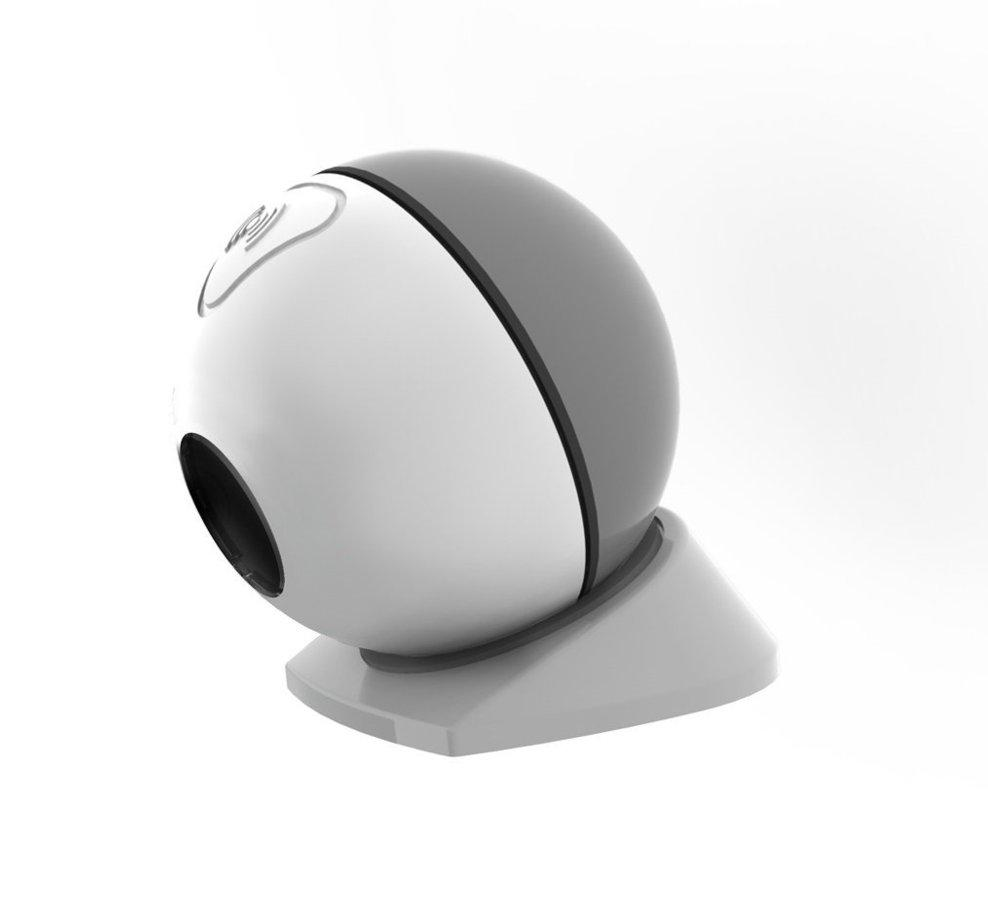 Dispositivo para el hogar inteligente en forma de huevo blanco y gris sobre una superficie blanca. Tiene una lente negra.