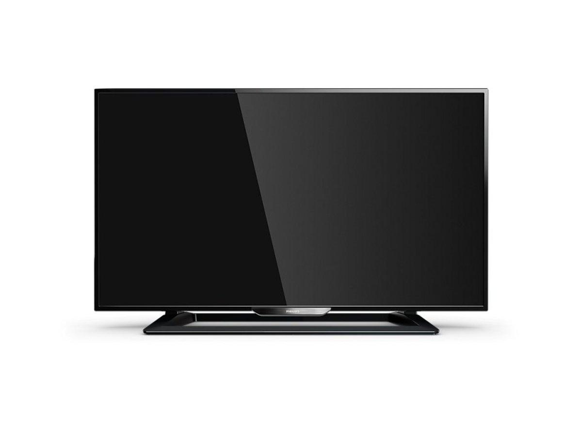 Televisor de pantalla plana negro sobre soporte negro, con pantalla reflectante.