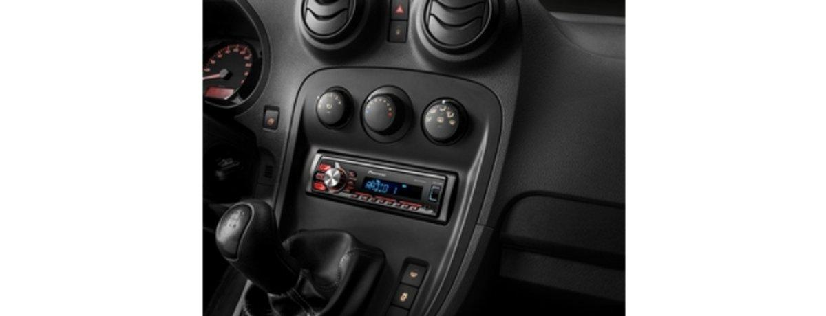 Interior de coche con radio, palanca de cambios y ventilación. Colores negro y gris.
