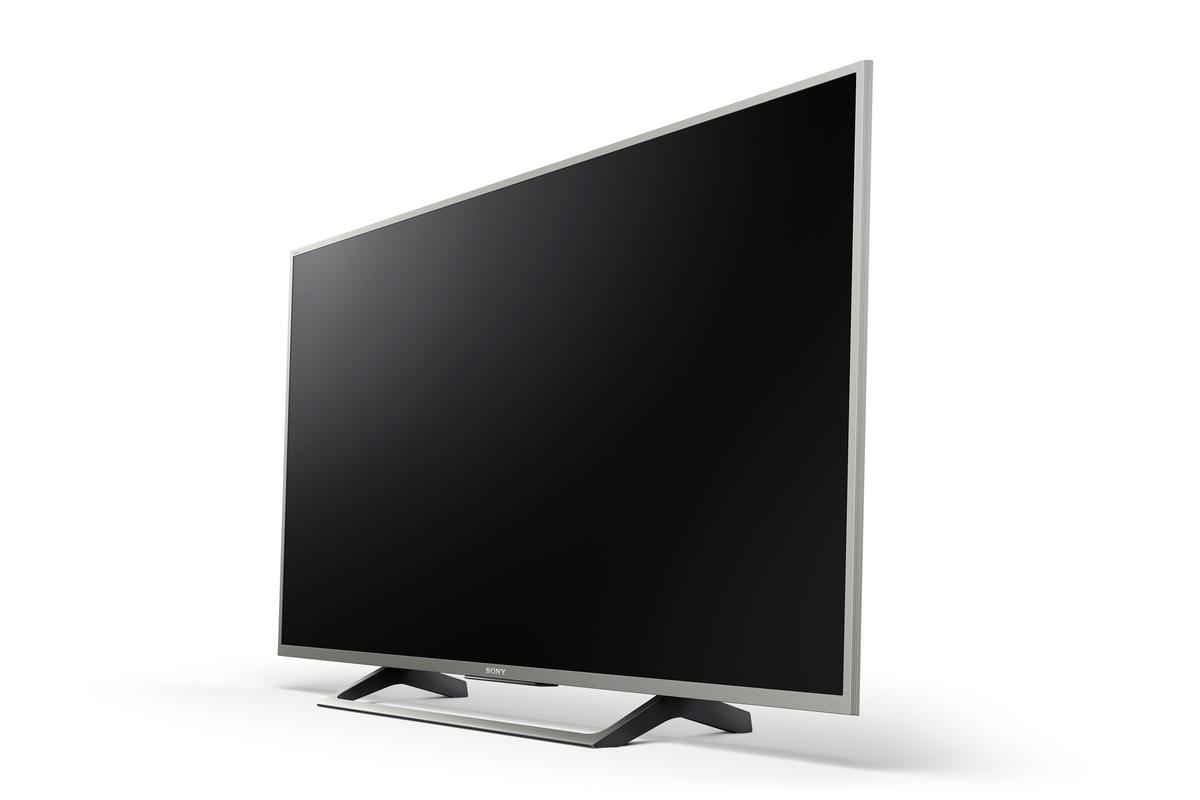 Un televisor Sony, en ángulo, con pantalla negra, marco plateado y soporte negro, sobre fondo blanco.