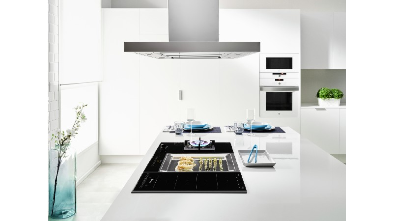 Placa de inducción negra con indicadores rojos. Cuatro zonas de cocción. Marca Bosch. Fondo blanco.