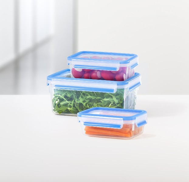 Tres recipientes transparentes para alimentos con tapas azules, llenos de comida.