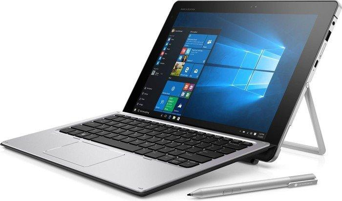 Ordenador portátil y teclado plateados con lápiz óptico sobre fondo blanco.