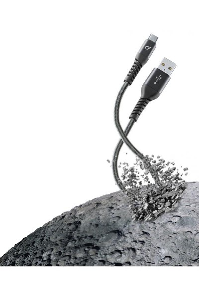 Cable USB-C negro y un cable USB, ambos cayendo de una superficie gris.