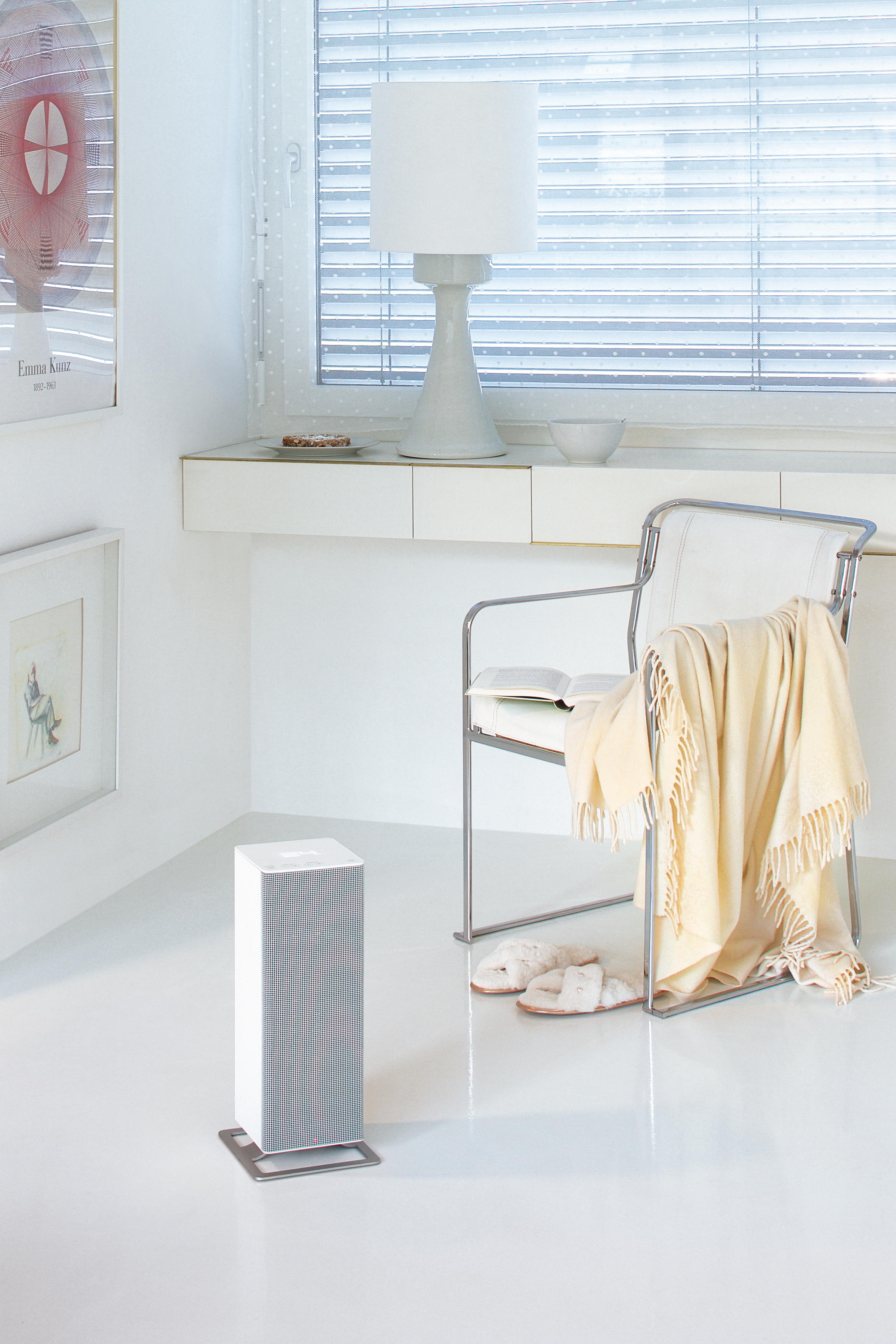 Modernes Interieur mit weißem Heizkörper, Stuhl mit Decke und Fenster. Helles Licht und weißer Boden.
