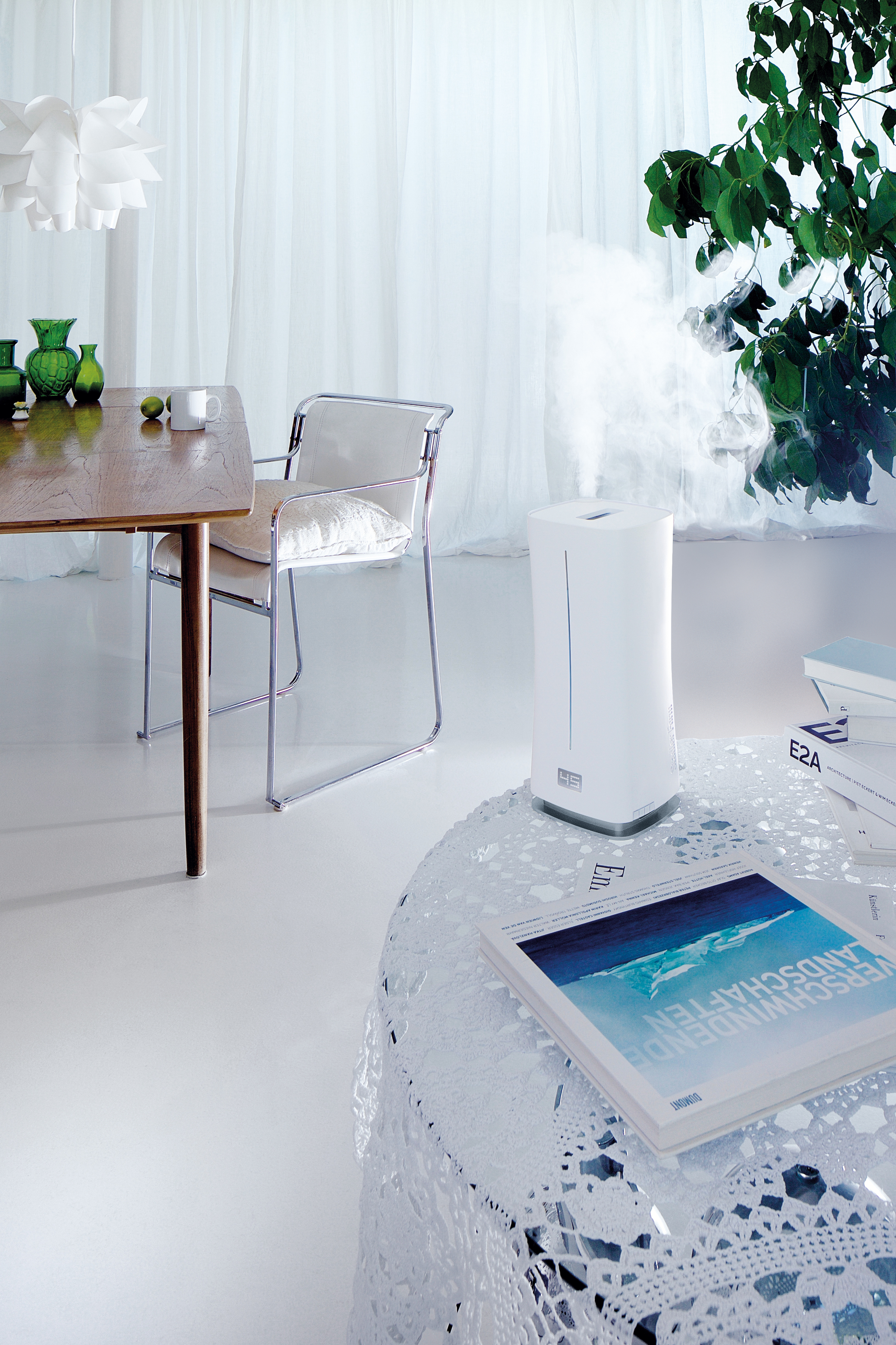 Modernes Interieur mit Luftbefeuchter, Tisch, Stuhl und Zeitschrift auf Tisch.