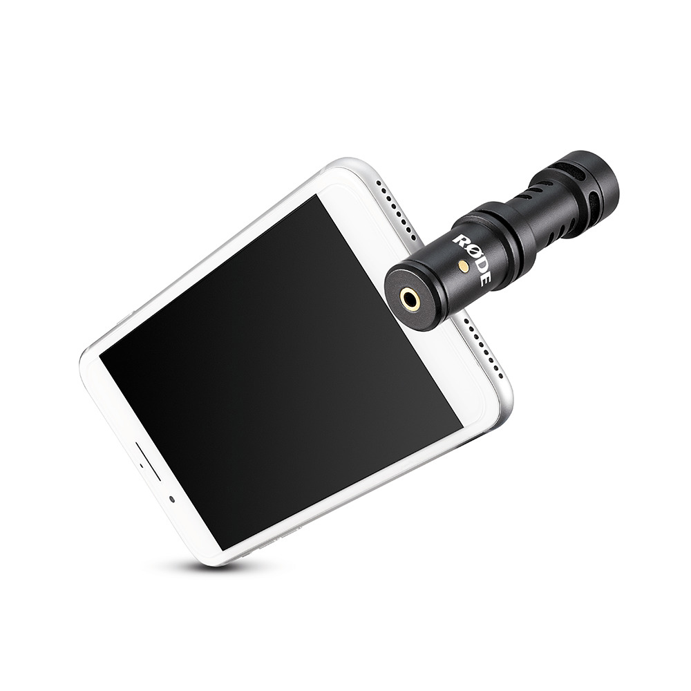Microphone noir attaché à un smartphone blanc.