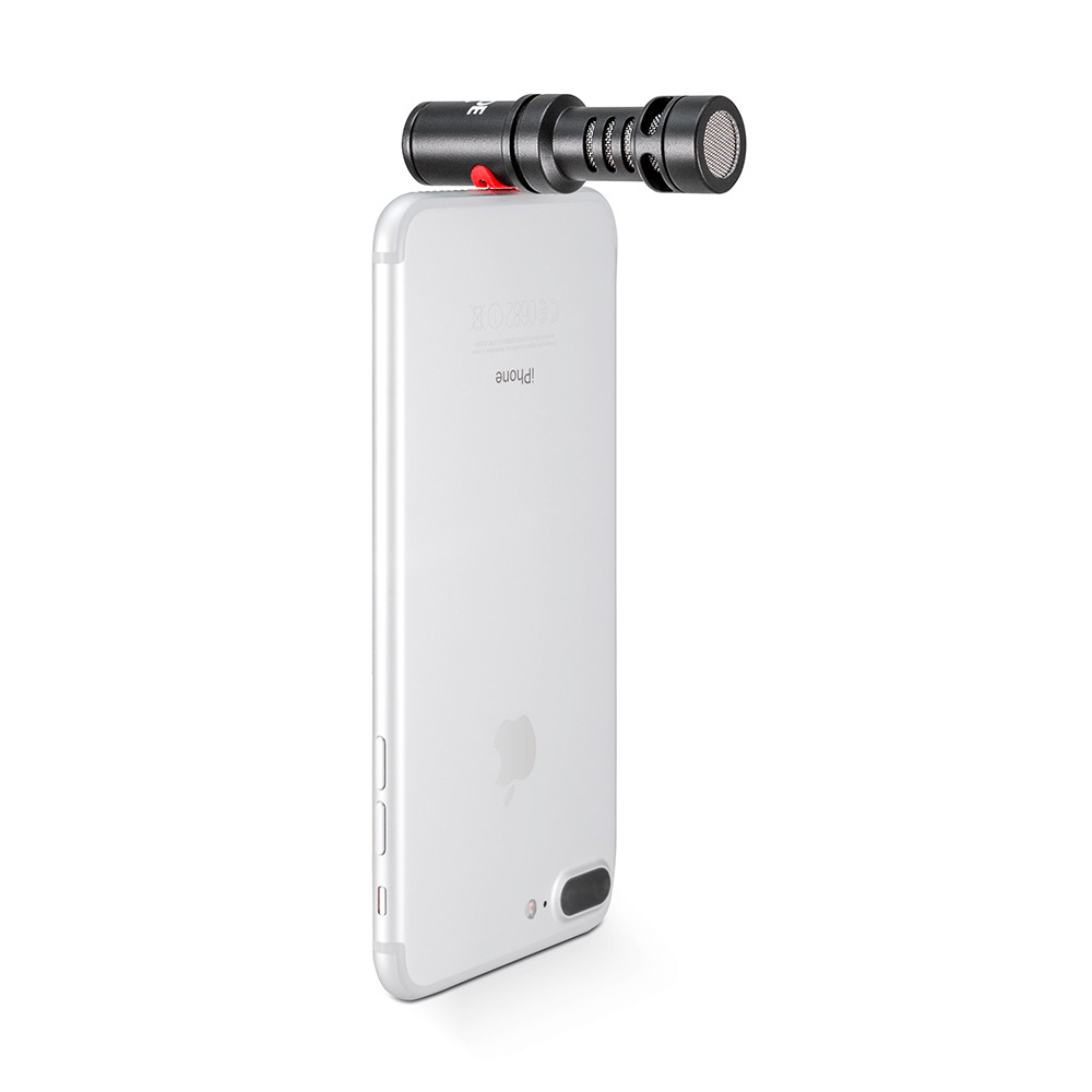Un iPhone avec un microphone attaché. Le microphone est noir et le téléphone est blanc.