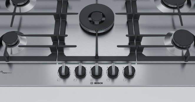 Encimera de gas de acero inoxidable con cinco quemadores, mandos negros y logo 'BOSCH'.